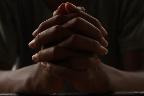 Hands clasped together in a resting position, illustrating stiffness and discomfort commonly linked to finger arthritis.