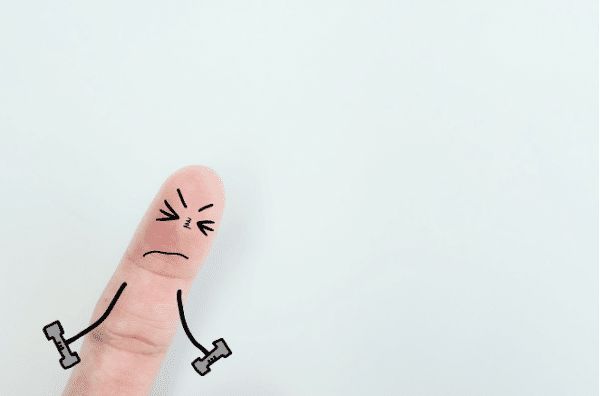 Cartoon Finger Showing Pain and Strain Cartoon-style finger with a drawn angry face and arms lifting weights, symbolising finger pain or strain.